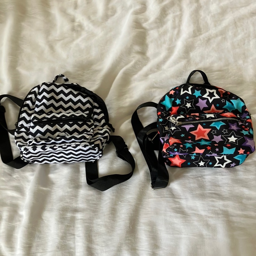 Two mini-backpacks, one with colored stars the other back and white stripes.